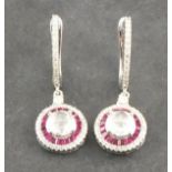 A pair of ruby and diamond ear pendants, the central rose cut stones within bands of rubies and