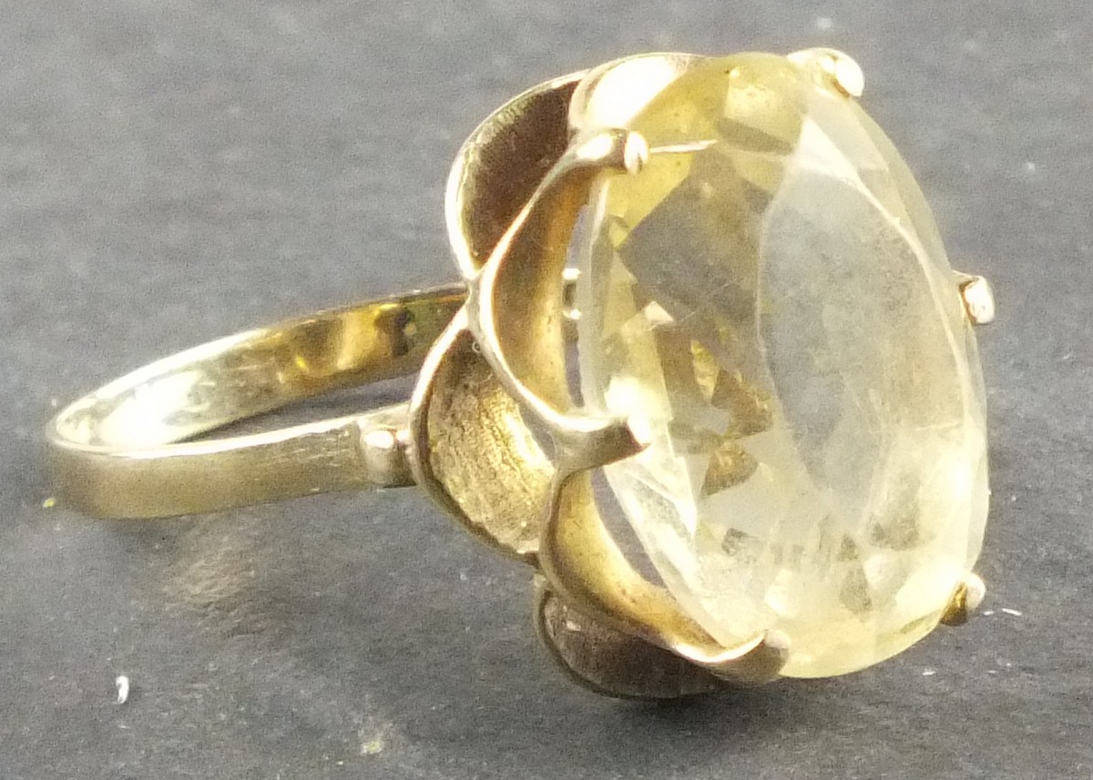 A citrine dress ring, circa 1960's, the oval faceted stone with a fancy setting and 9ct gold band,