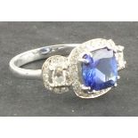 A tanzanite and diamond dress ring, the central emerald cut stone approx 2.84ct within a band of