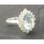 A aquamarine and diamond set dress ring, the central stone approx 5.25ct claw set within a band of