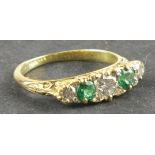 An emerald and diamond five stone dress ring, the stones with a pierced fancy setting on an 18ct