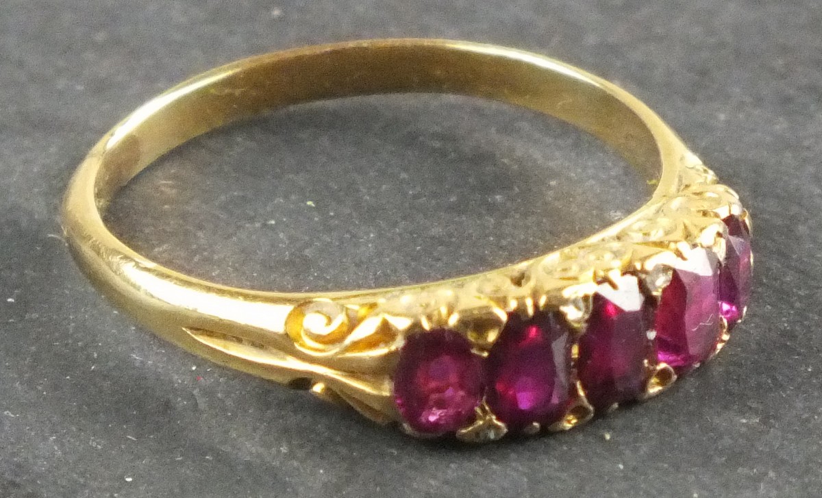 A five stone ruby dress ring, with a pierced fancy setting and 18ct gold band, 3.2g