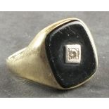 A gentleman's onyx and diamond set plaque ring, the rectangular plaque set with a central diamond on