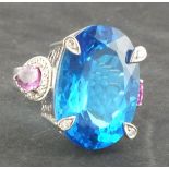 A topaz, sapphire and diamond cocktail ring, the oval central stone approx 35ct flanked by a pair of