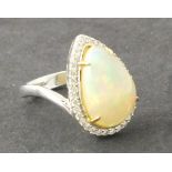 An opal and diamond cluster ring, the pear shaped central stone approx, 4.4ct within a band of