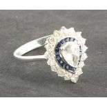 A sapphire and diamond dress ring, the pear shaped central stone within a band of sapphires and