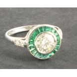 An emerald and diamond dress ring, target style set in 14ct white gold, 2.7g