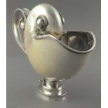 A white metal mounted nautilus shell gravy boat, the polished shell with rope-twist and scrolled