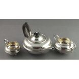 A silver three piece tea service, Chester 1905 - W. Neal, of squat circular form with a reeded