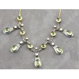 A peridot and diamond fringe necklace, the cabochon stones mounted in pendents and suspended from