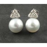 A pair of South Sea pearl and diamond ear studs, the pearls suspended from a bail of three diamonds,