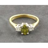A three stone diamond ring, the central fancy green/yellow baguette cut stone (treated) 0.65ct