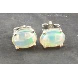 A pair of opal ear studs, the oval cabochon stones claw set on silver posts