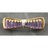 An amethyst and diamond bow brooch, the arrangement of baguette cut graduated stones set in 9ct