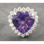 An amethyst dress ring, the heart-shaped central stone claw set within a band of white stones on a