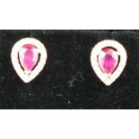 A pair of ruby and diamond ear studs,  the drop shaped central stones, total wight 1.19ct, within