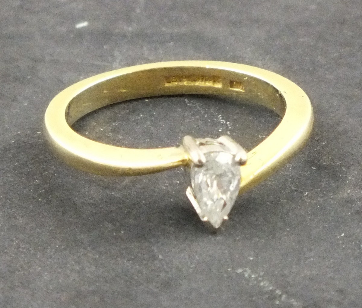 A solitaire diamond ring, the pear shaped stone approx. 0.4 ct set in an 18ct yellow gold band, 2.9g