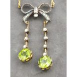 A peridot and seed pearl pendent necklace, the drops suspended from a bow