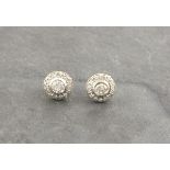A pair of diamond ear studs, the central stones each within a band of small stones, 1.6g
