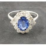 A sapphire and dimaond dress ring, the central oval stone 2.09ct within a band of baguette and