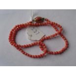 A single string of coral beads, fastening with an oval coral bead