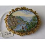A large gold mounted painted river scene brooch 6.5cm wide