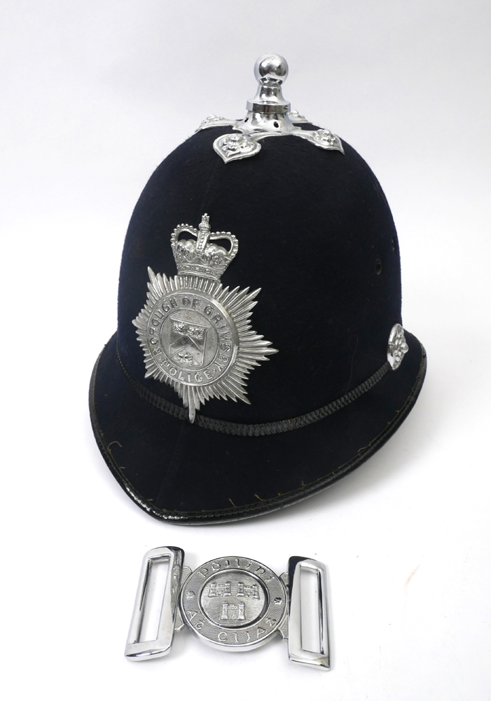 Polini Ath Cliath belt buckle and a police helmet. The white metal two piece buckle centred with the