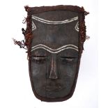 Tribal mask, Congo tribe. A carved wood mask the eyelids and nose of beaten copper, with fabric