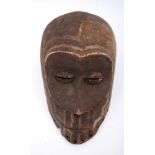 Tribal mask, Luba, Congo. A carved wood mask, the forehead and eye sockets exaggerated, metal