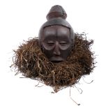 Tribal mask, Luba, Congo. A carved wood mask, the head crowned with a 'bun', the rim with a grass