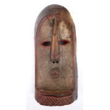 Tribal mask, Kuba, Congo. A painted, carved wood arch-shaped mask, the white face with pierced,