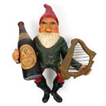 1961 Guinness leprechaun, truck ornament. A figure of a leprechaun dressed in a red pointed hat,