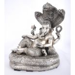 A white metal figure of Ganesha. Depicted with elephant head and four arms, the upper arms holding