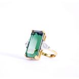 A tourmaline and diamond cocktail ring. A large, emerald-cut, dark green tourmaline flanked by two