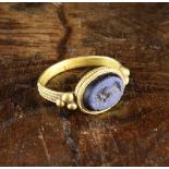 A Roman Gold-coloured Ring with carved blue stone (possibly lapis) intaglio; portrait of an Emperor.