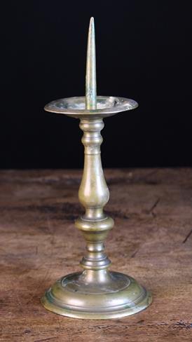 A 17th Century Bronze Pricket Candlestick with an acorn knopped baluster stem and turned foot,