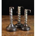 Three Early 19th Century Spiral Strap Candlesticks with turned treen bases;