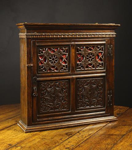 An Attractive 17th Century Joined Oak Mural Cupboard with pierced and carved panels.