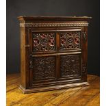 An Attractive 17th Century Joined Oak Mural Cupboard with pierced and carved panels.