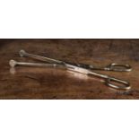 A Pair of Early 18th Century Brass Tongs embellished with engraved scrolls of foliage,