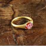 A Roman Gold-coloured Ring with red stone intaglio carved with an amphora.