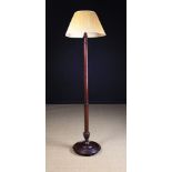 A Tall Turned Mahogany Standard Lamp with pleated cream silk shade.