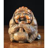 A 19th Century Japanese Carved Bamboo Tobacco Box carved in the form of Daikokuten sat crouched