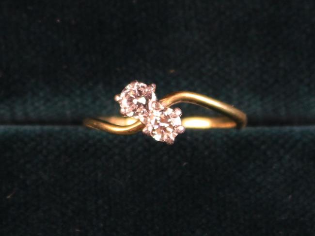 An 18 Carat Gold & Diamond Ring; set with two stones each approximately .25 carat on a twist mount.