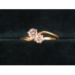 An 18 Carat Gold & Diamond Ring; set with two stones each approximately .25 carat on a twist mount.