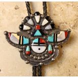 A Zuni Silver "Sun Face and Buffalo Dancer" Bolo, inlaid with turquoise, red coral and jet.