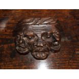 A 15th Century Carved Oak Boss in the form of three conjoined grotesque heads, 4½ in (11.