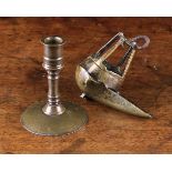 An Early Patinated Copper Alloy Candlestick with a flanged socket and reel stem peaned to a