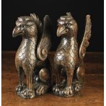 A Pair of Elizabethan Oak Figural Supports carved in the form of seated griffins with upswept