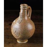 A Late 17th Century Bellarmine Flagon having a bearded facemask above an oval medallion with a